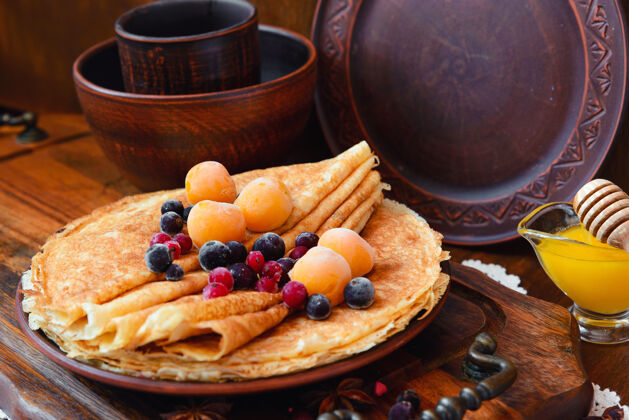 糖浆金煎饼 冷冻水果 装饰和蜂蜜在一个乡村风格吃甜的栈