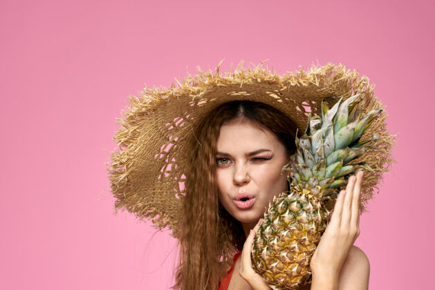 异国水果美国水果趣味化妆品粉色背景上戴草帽的女人深色女性果汁