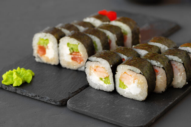 新鲜在灰色桌子上的石板上放着Maki寿司卷 特写寿司菜单Rollsups传统