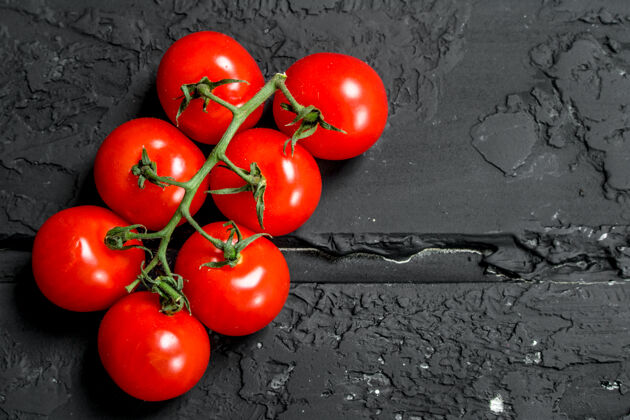 切熟番茄分支机构一张黑色的乡村桌子樱桃番茄新鲜