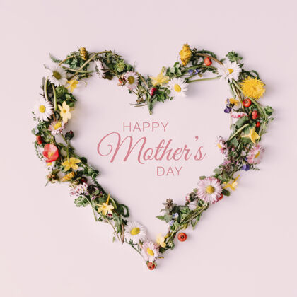 玫瑰白色表面上用花絮和树叶做成的心形符号 上面印有“母亲节快乐”字样咖啡浆果快乐