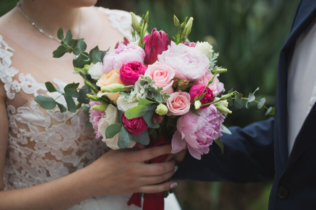 夫妇新娘手里捧着一束鲜花一起美丽夏天