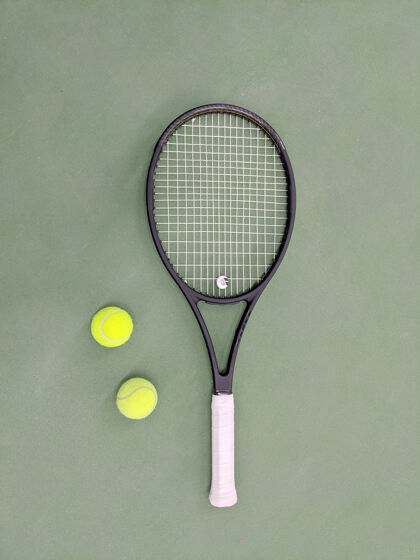 球场网球拍和两个球在绿泥网球场上的俯视图设备背景比赛