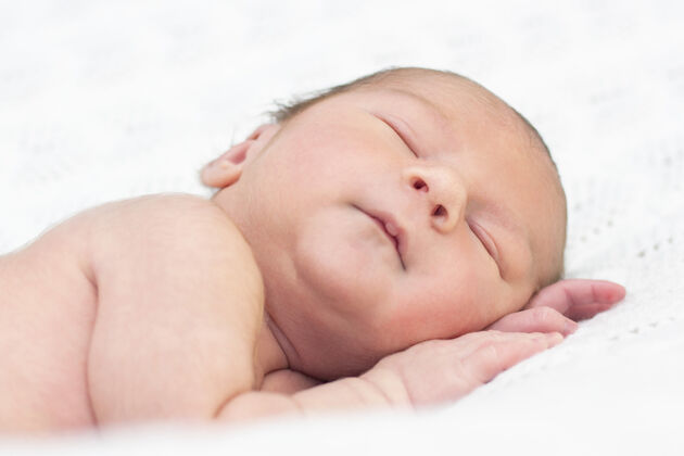 休息新生婴儿睡觉和睡觉微笑接近美丽的熟睡婴儿的画像毯子新生儿夜晚