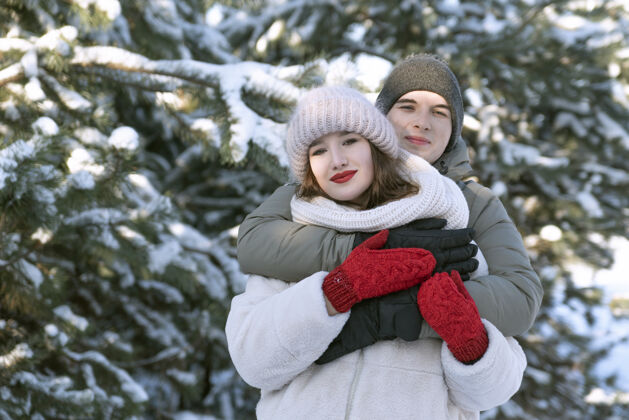 拥抱在雪域森林的背景下 一对年轻的恋人拥抱在一起女朋友家庭情侣