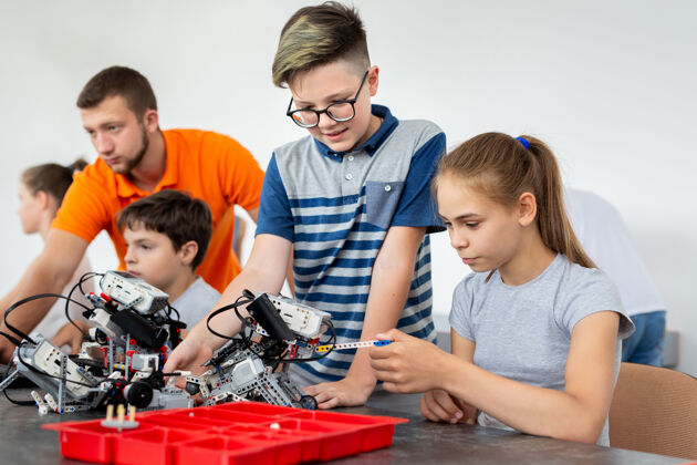 电子孩子们和老师一起做他们的机器人教育项目年轻课程学习