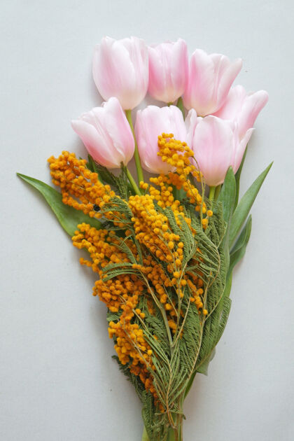 束美丽的粉红色郁金香和含羞草花婚礼庆祝生日