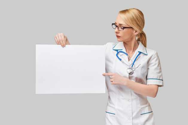 人物女医生拿着一张白纸或海报笑脸内容白种人