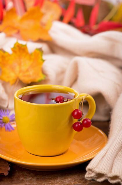 热一杯热茶和秋叶 在棕色的背景上玻璃肉桂自然