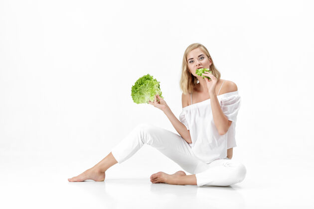 饮食一个穿着白衬衫的金发美女在白衬衫上吃着新鲜的蔬菜沙拉背景.健康还有节食人生活方式健康饮食