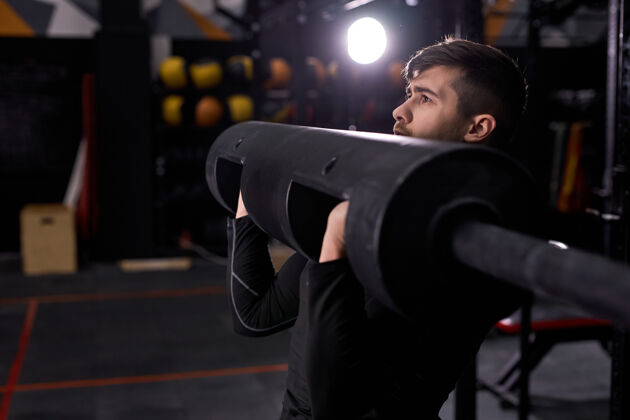 私人教练肌肉发达的男子举重 训练手臂肌肉强壮的男子在现代健身中心使用运动器材 健身房男穿着运动装 专注于锻炼运动健身房肌肉