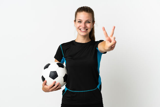庆典一个年轻的足球运动员 一个在白色背景下微笑着展示胜利标志的女人女人成功是的