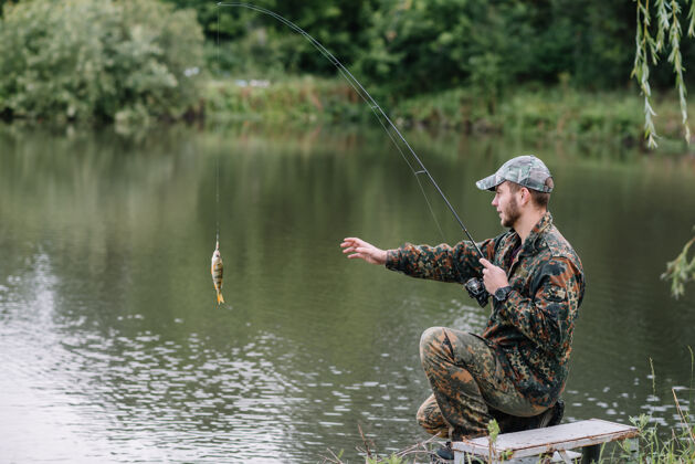湖泊一个渔夫拿着鱼竿在河岸上钓鱼放松水
