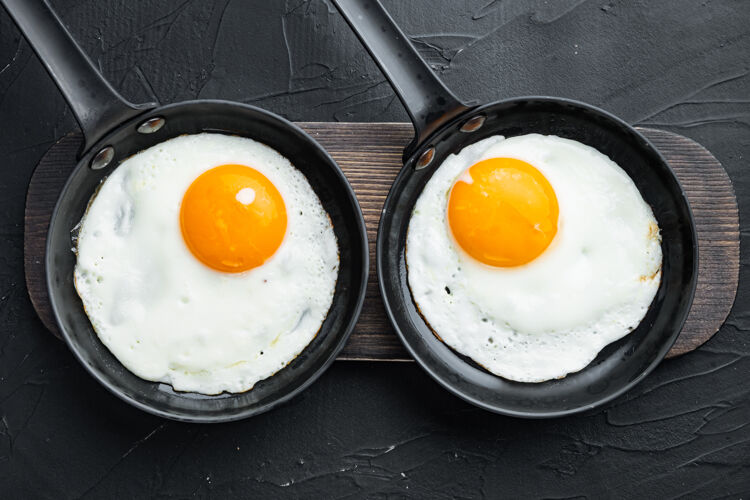 煎蛋卷早餐用铸铁煎锅煎鸡蛋 樱桃西红柿和面包平底锅胆固醇培根