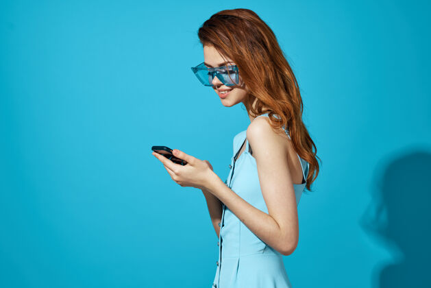 电话戴着蓝色眼镜的漂亮女人手里拿着电话通讯技术孤立了手机欢呼电话