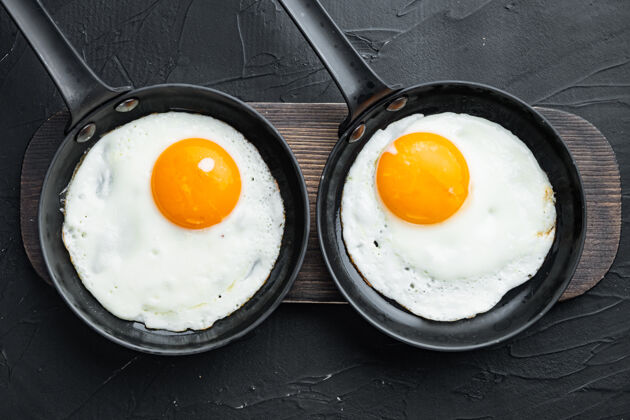 煎蛋卷早餐用铸铁煎锅煎鸡蛋 樱桃西红柿和面包平底锅胆固醇培根