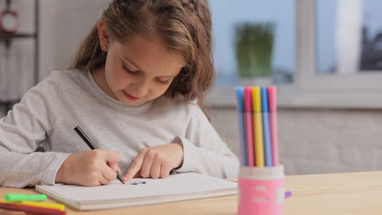 人小女孩用毛笔在白纸上画画相册.播放独自一人 在家里进行创造性的艺术活动女孩绘画肖像