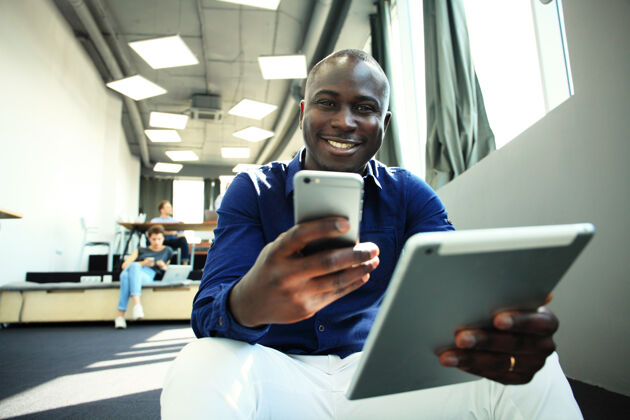 专业人士快乐的非洲裔美国企业家使用平板电脑正式聪明人商人