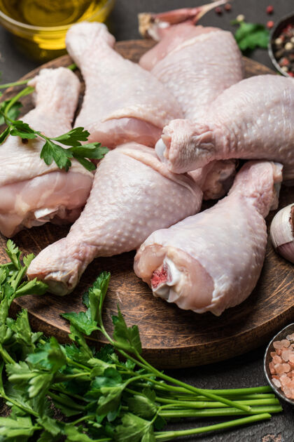 准备生鸡腿 用香料和配料在砧板上烹饪生的肉鸡配料