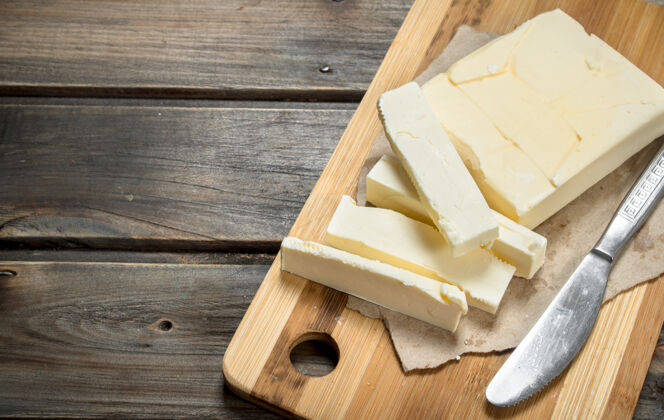 食物用刀在木板上涂黄油切割营养胆固醇