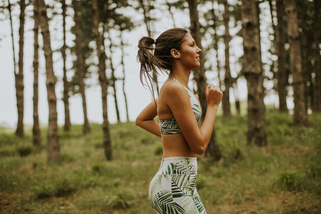 行动在森林小道上跑步的年轻漂亮的健身女士减肥私人教练森林