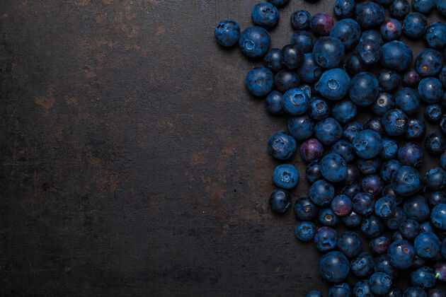 背景俯瞰躺在古老乡村背景上的一堆蓝莓新鲜蓝色饮食