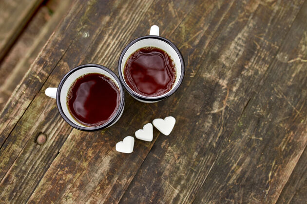 饮料用棉花糖在木制表面涂上瓷釉的茶杯冒险情侣搪瓷