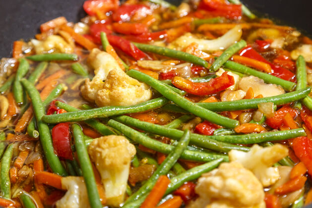 午餐在泛亚洲酱蔬菜在锅特写炸鸡鸡肉薯条