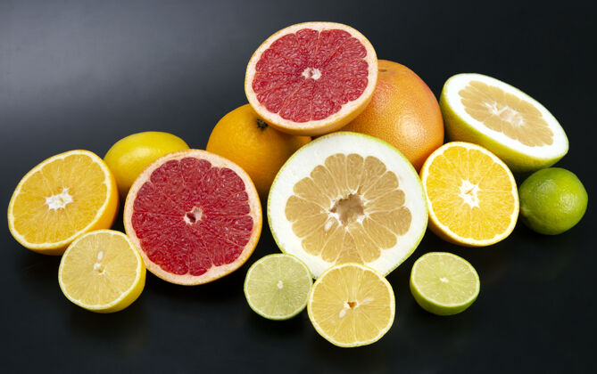 五颜六色在深色的背景上切块不同的柑橘类水果美味柠檬分类