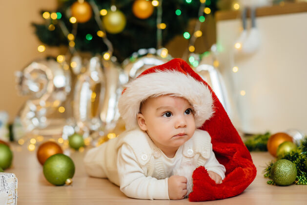 幼儿可爱的微笑着的婴儿躺在圣诞树下和孩子们玩耍礼物.圣诞节还有新年庆祝活动宝宝圣诞宝宝新