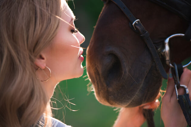 公园美丽的女孩和马蹄和她最喜欢的主人一起骑马的年轻少女骑手骑士草地