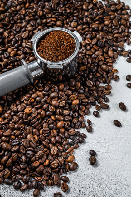 食物在portafilter中研磨咖啡 用于浓缩咖啡 咖啡豆在其上白色上衣查看马克杯热饮料磨碎的