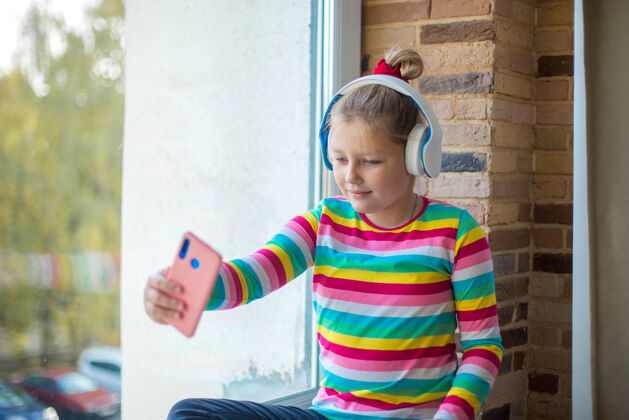 童年女孩戴着耳机听音乐自拍小窗户自拍