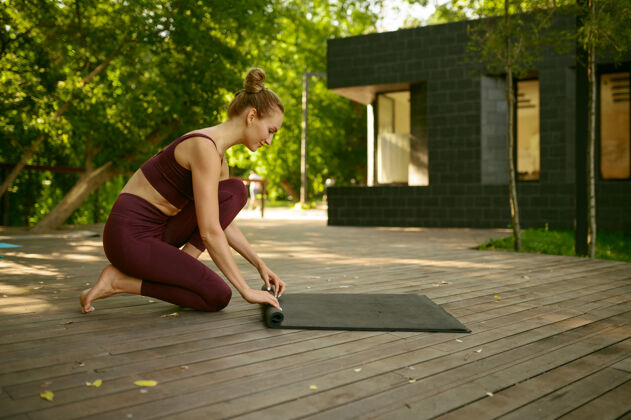 快乐阳光明媚的公园里 苗条的女人在瑜伽训练后扭动着垫子健身房私人教练健康