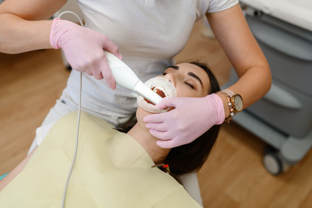 牙科女牙医在诊所 口腔科和病人的牙齿一起工作职业患者