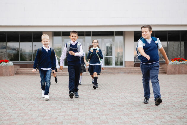 活跃一群穿着校服的小学生兴高采烈地跑出了学校乐趣高尔夫朋友