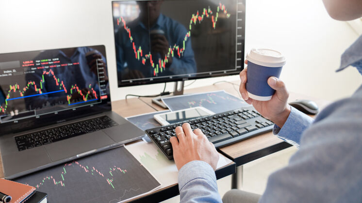 数据商人经纪人在屏幕上分析财务数据图表和报告交易所计算机成功