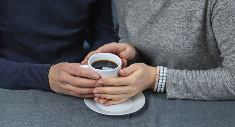 咖啡一男一女端着一杯咖啡坐在桌边杯子早餐复制空间
