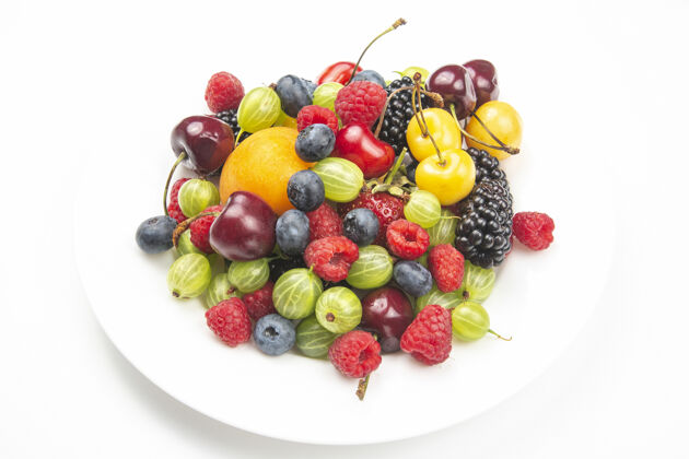 覆盆子各种新鲜的浆果放在白色的蛋糕上板.有用的维生素保健食品水果健康蔬菜早餐水果混合醋栗