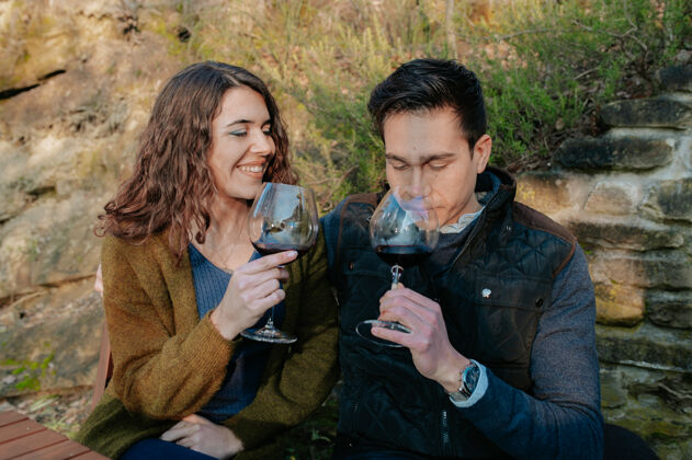 酒精一对年轻的浪漫情侣在野餐时坐在花园里品尝一杯红酒质量餐馆乐趣