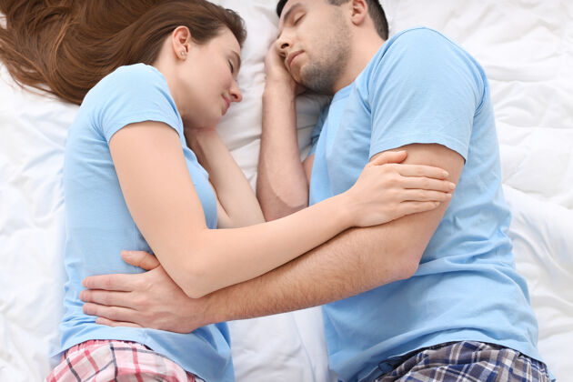 女人睡在床上的年轻夫妇成人丈夫放松