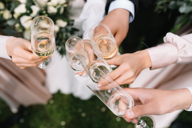 干杯宾客在婚礼上与新郎新娘碰杯香槟或白葡萄酒祝贺客人酒杯