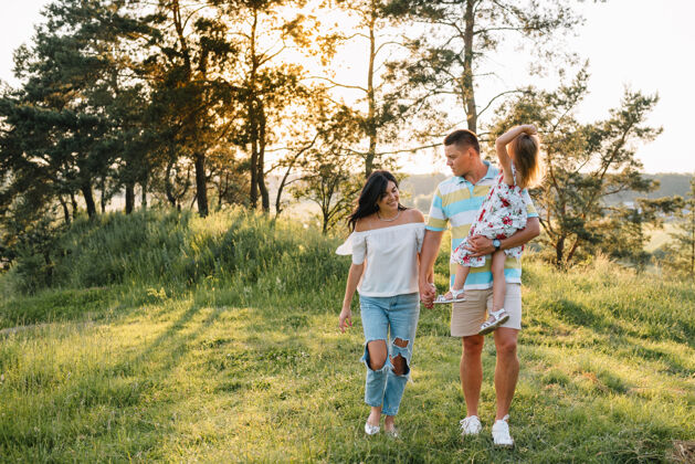 时刻快乐家庭的概念-爸爸 妈妈和孩子女儿在大自然中快乐玩耍欢呼飞行休闲