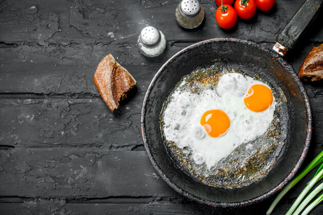 早餐在平底锅里煎鸡蛋 配上面包和西红柿健康油白色