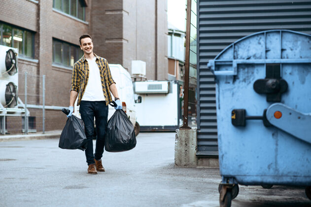 再利用志愿者把塑料垃圾袋带到户外的垃圾桶里 志愿者人清洁城市街道 生态修复 垃圾回收 生态关怀 环境清洁垃圾袋子社区