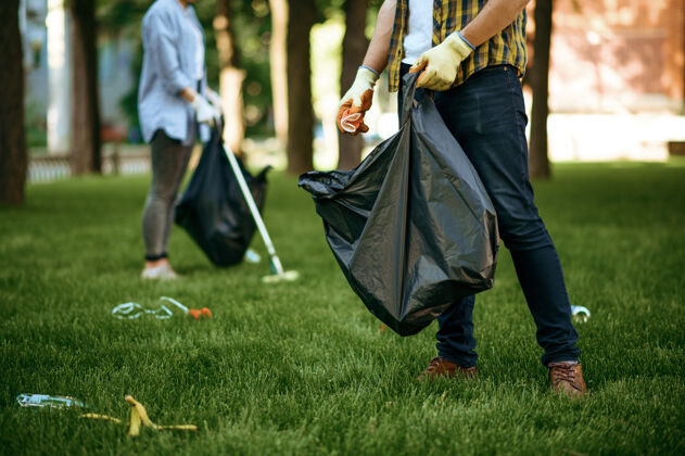 挑选人们在公园里用袋子收集垃圾 志愿服务男人清林 生态修复 生态生活方式 垃圾收集回收 生态关爱 环境清洁材料生态瓶子