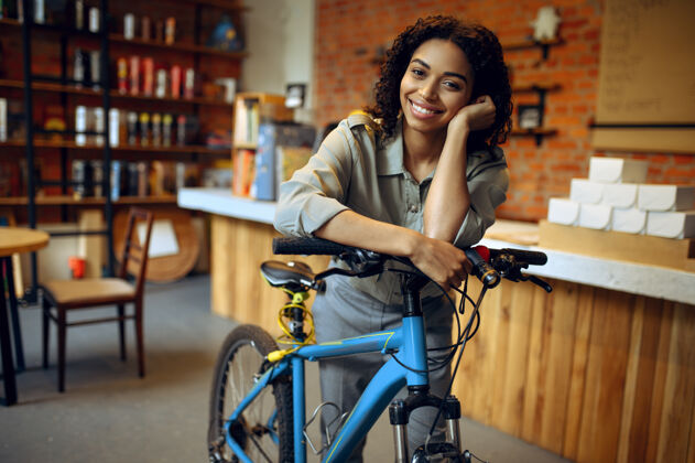 快乐微笑的女学生在教室里和自行车合影女咖啡馆带循环输入咖啡馆女孩校园自助餐厅休闲酒吧真实饮料
