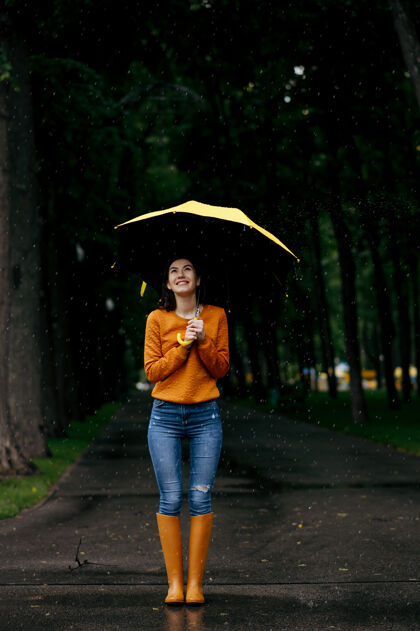 快乐带伞的女人 背景 夏日公园里的雨 雨天白天女性独自行走的人 小巷里的潮湿天气浪漫雨伞女人
