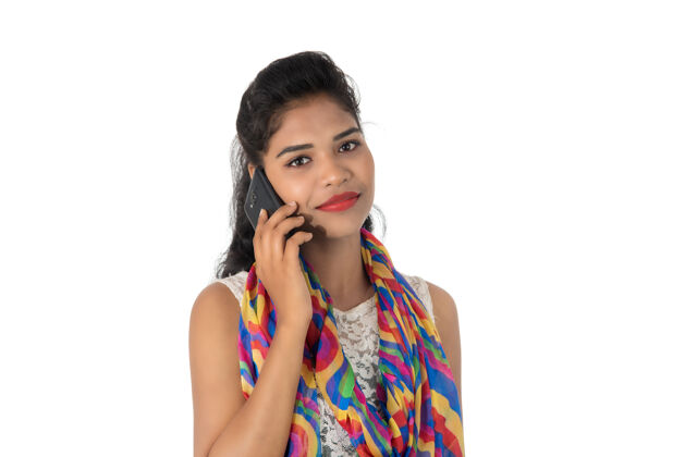科技年轻的印度女孩用手机或智能手机隔离在白色电话女士成人
