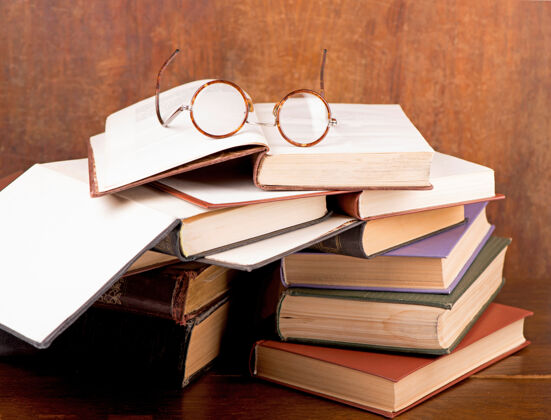 文学旧精装书和老式眼镜与圆镜片在黑暗的背景刻字研究作者